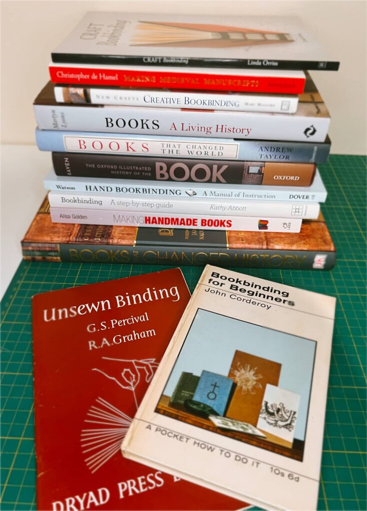 A pile of various books all regarding book binding and the history of books